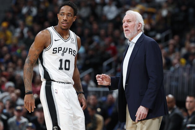 San Antonio Spurs guard DeMar DeRozan, left, confers with coach Gregg Popovich during a timeout in the second half of the team's NBA basketball game against the Denver Nuggets on Friday, Dec. 28, 2018, in Denver. The Nuggets won 102-99. (AP Photo/David Zalubowski)