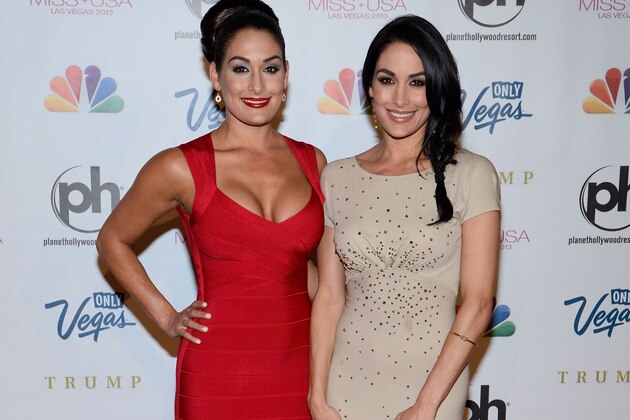 From left, Professional wrestler and pageant judge Nikki Bella and her twin sister, professional wrestler Brie Bella, arrive at the Miss USA 2013 pageant, Sunday, June 16, 2013, in Las Vegas. (AP Photo/Jeff Bottari)