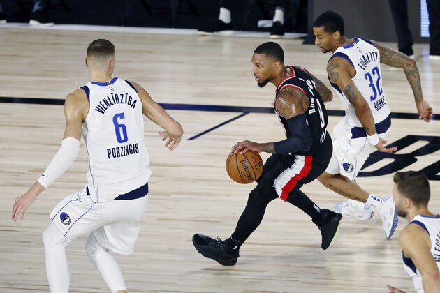 Portland Trail Blazers guard Damian Lillard (0) dribbles through the Dallas Mavericks defense during the first half of an NBA basketball game Tuesday, Aug. 11, 2020, in Lake Buena Vista, Fla. (Kim Klement/Pool Photo via AP)