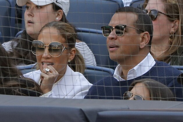 Actress Jennifer Lopez, left, and former major league baseball player Alex Rodriguez watch a baseball game between the New York Yankees and the Baltimore Orioles, Saturday, March 30, 2019, in New York. (AP Photo/Julie Jacobson)