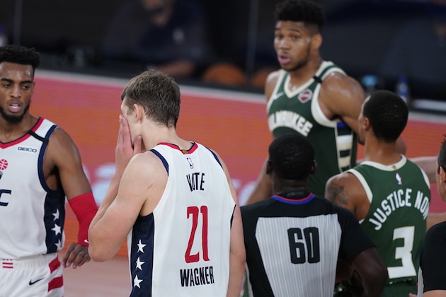 Washington Wizards' Moritz Wagner (21) grabs his face after getting head butted by Milwaukee Bucks' Giannis Antetokounmpo, rear, during the first half of an NBA basketball game, Tuesday, Aug. 11, 2020, in Lake Buena Vista, Fla. Antetokounmpo was ejected from the game. (AP Photo/Ashley Landis, Pool) Washington Wizards' Moritz Wagner (21) grabs his face after getting head butted by Milwaukee Bucks' Giannis Antetokounmpo, rear, during the first half of an NBA basketball game, Tuesday, Aug. 11, 2020, in Lake Buena Vista, Fla. Antetokounmpo was ejected from the game. (AP Photo/Ashley Landis, Pool)
