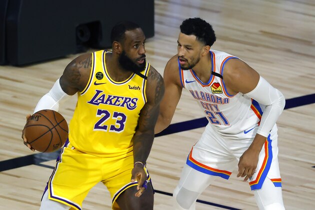 LeBron James, right, of the Los Angeles Lakers is defended by Andre Roberson, left, of the Oklahoma City Thunder during the first quarter during an NBA basketball game Wednesday, Aug. 5, 2020, in Lake Buena Vista, Fla. (Kevin C. Cox/Pool Photo via AP)