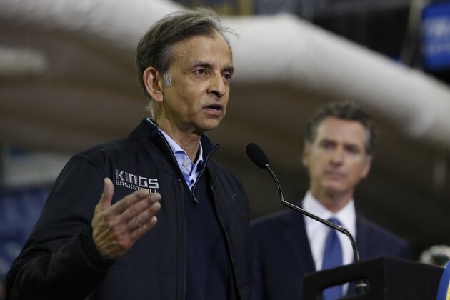Vivek Ranadive, left, the owner of the NBA's Sacramento Kings basketball team, flanked by Gov. Gavin Newsom, right, discusses the donation of Sleep Train Arena, the team's former home, for use as a field hospital, after touring the facility in Sacramento, Calif., Monday, April 6, 2020. The arena is being transformed for use as a 400-bed emergency field hospital to help deal with the coronavirus outbreak. (AP Photo/Rich Pedroncelli, Pool)