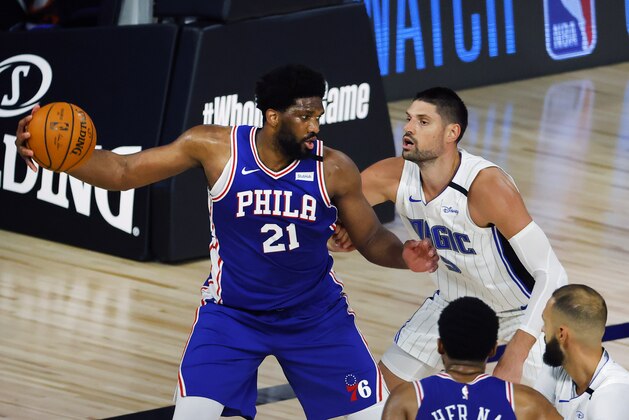 Philadelphia 76ers' Joel Embiid (21) is defended by Orlando Magic's Nikola Vucevic during the second half of an NBA basketball game Friday, Aug. 7, 2020, in Lake Buena Vista, Fla. (Kevin C. Cox/Pool Photo via AP)