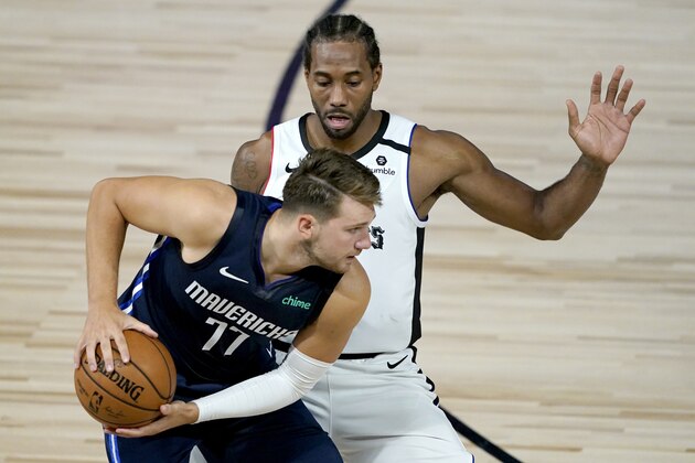Los Angeles Clippers' Kawhi Leonard, right, applies pressure on Dallas Mavericks' Luka Doncic (77) during the second half of an NBA basketball game Thursday, Aug. 6, 2020 in Lake Buena Vista, Fla. (AP Photo/Ashley Landis, Pool)