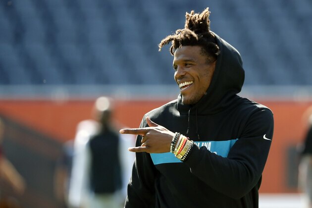 Carolina Panthers quarterback Cam Newton smiles and points at a teammates before an NFL preseason football game against the Chicago Bears Thursday, Aug. 8, 2019, in Chicago. (AP Photo/Charles Rex Arbogast)