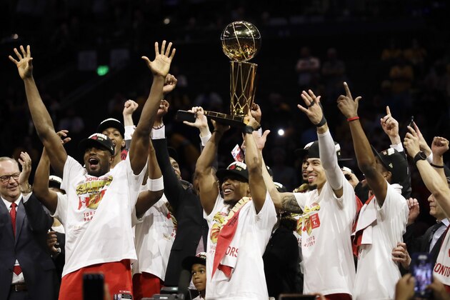 Toronto Raptors center Serge Ibaka, left, guard Kyle Lowry, center, and guard Danny Green, third from right, celebrate with teammates after the Raptors defeated the Golden State Warriors in Game 6 of basketball's NBA Finals in Oakland, Calif., Thursday, June 13, 2019. (AP Photo/Ben Margot)
