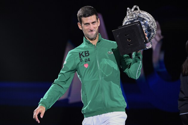 Serbia's Novak Djokovic carries the Norman Brookes Challenge Cup after defeating Austria's Dominic Thiem in the final of the Australian Open tennis championship in Melbourne, Australia, Monday, Feb. 3, 2020. (AP Photo/Andy Brownbill)