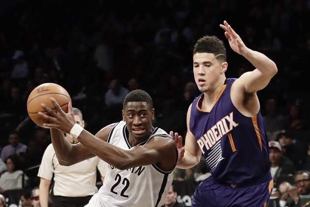 Brooklyn Nets' Caris LeVert (22) drives past Phoenix Suns' Devin Booker (1) during the first half of an NBA basketball game Thursday, March 23, 2017, in New York. (AP Photo/Frank Franklin II)