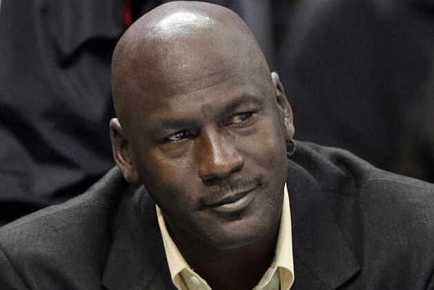 FILE - In this April 16, 2014, file photo, Charlotte Bobcats owner Michael Jordan watches an NBA basketball game between the Bobcats and the Chicago Bulls in Charlotte, N.C. The six-time NBA champion is scheduled to appear Tuesday, Aug. 11, 2015, in federal court in Chicago for the start of a civil trial and will later testify on the unauthorized use of his identity. A court already ruled a grocery-story chain used his identity without permission in a magazine ad and so the unresolved legal issue is damages. (AP Photo/Chuck Burton, File)