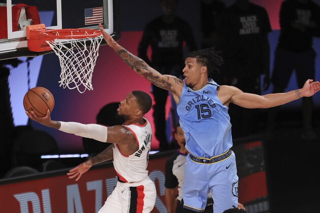 Portland Trail Blazers Damian Lillard (0) shoots the ball against Memphis Grizzlies Brandon Clarke (15) during the second half of an NBA basketball game Friday, July 31, 2020, in Lake Buena Vista, Fla. (Mike Ehrmann/Pool Photo via AP)