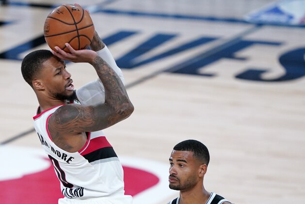 Portland Trail Blazers' Damian Lillard, left, goes up with the ball against Brooklyn Nets' Timothe Luwawu-Cabarrot during the first half of an NBA basketball game Thursday, Aug. 13, 2020 in Lake Buena Vista, Fla. (AP Photo/Ashley Landis, Pool)