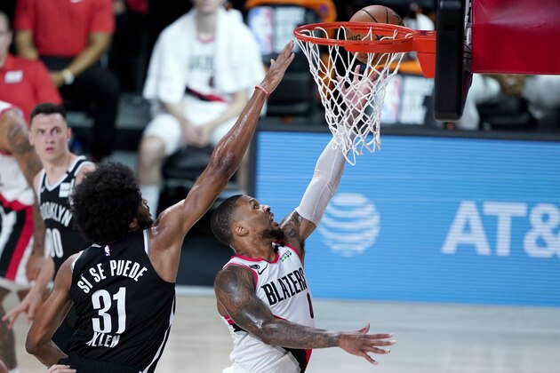 Portland Trail Blazers' Damian Lillard, right, goes up for a shot against Brooklyn Nets' Jarrett Allen (31) during the first half of an NBA basketball game Thursday, Aug. 13, 2020 in Lake Buena Vista, Fla. (AP Photo/Ashley Landis, Pool)