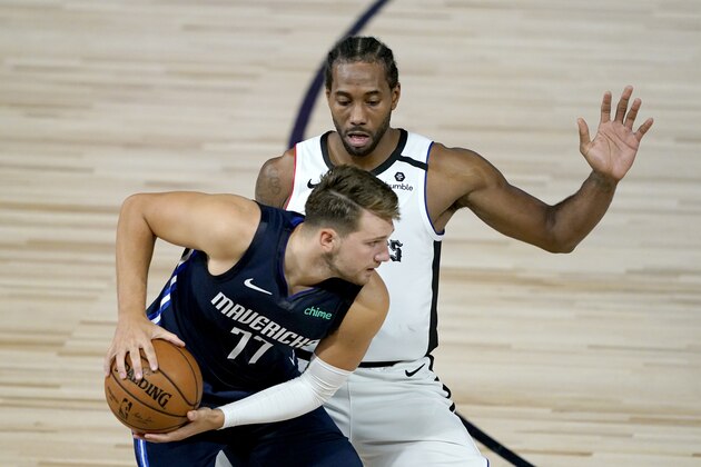 Los Angeles Clippers' Kawhi Leonard, right, applies pressure on Dallas Mavericks' Luka Doncic (77) during the second half of an NBA basketball game Thursday, Aug. 6, 2020 in Lake Buena Vista, Fla. (AP Photo/Ashley Landis, Pool)