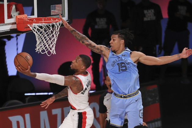 Portland Trail Blazers Damian Lillard (0) shoots the ball against Memphis Grizzlies Brandon Clarke (15) during the second half of an NBA basketball game Friday, July 31, 2020, in Lake Buena Vista, Fla. (Mike Ehrmann/Pool Photo via AP) Portland Trail Blazers Damian Lillard (0) shoots the ball against Memphis Grizzlies Brandon Clarke (15) during the second half of an NBA basketball game Friday, July 31, 2020, in Lake Buena Vista, Fla. (Mike Ehrmann/Pool Photo via AP)