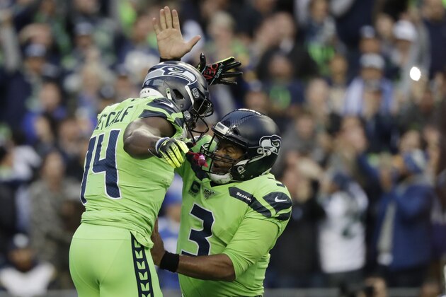 Seattle Seahawks quarterback Russell Wilson, right, celebrates with wide receiver DK Metcalf, left, after Metcalf scored a touchdown against the Los Angeles Rams during the first half of an NFL football game, Thursday, Oct. 3, 2019, in Seattle. (AP Photo/Elaine Thompson)