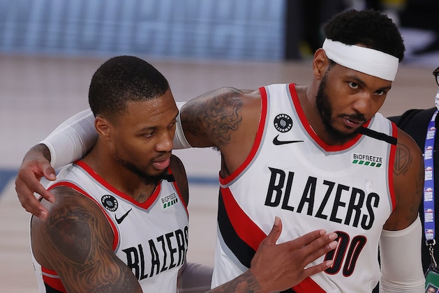 Portland Trail Blazers' Carmelo Anthony, right, and Damian Lillard celebrate the team's win over the Philadelphia 76ers in an NBA basketball game Sunday, Aug. 9, 2020, in Lake Buena Vista, Fla. (Kevin C. Cox/Pool Photo via AP)
