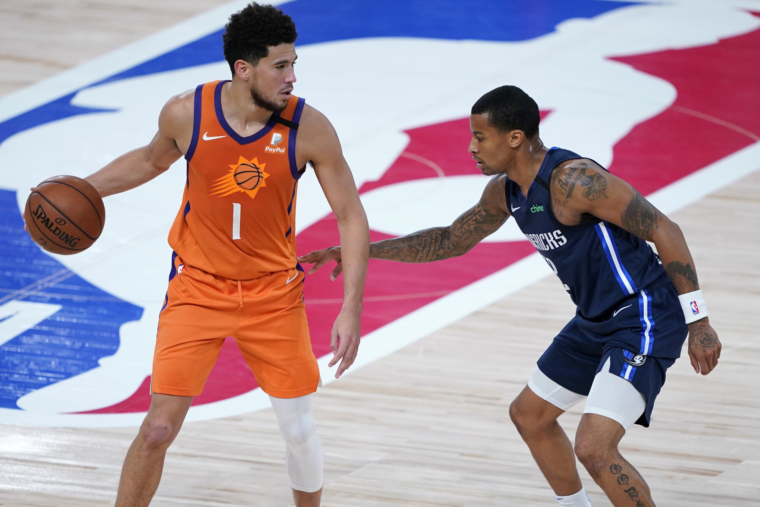 Phoenix Suns' Devin Booker (1) dribbles as Dallas Mavericks' Trey Burke defends during the second half of an NBA basketball game Thursday, Aug. 13, 2020 in Lake Buena Vista, Fla. (AP Photo/Ashley Landis, Pool)