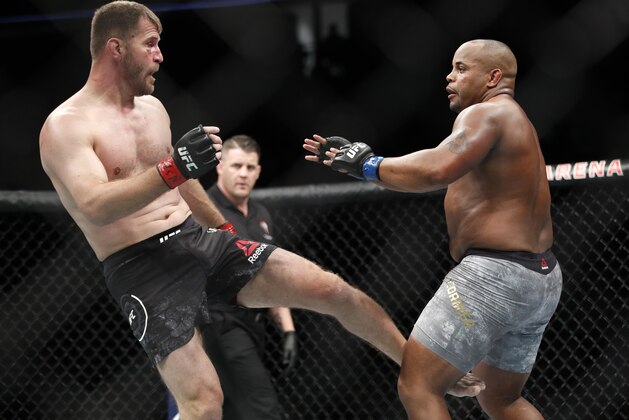 Stipe Miocic kicks Daniel Cormier during a heavyweight title mixed martial arts bout at UFC 226, Saturday, July 7, 2018, in Las Vegas. (AP Photo/John Locher)