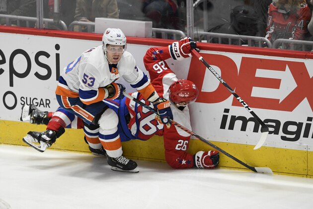 Washington Capitals center Nic Dowd (26) collides into the boards next to New York Islanders center Casey Cizikas (53) during the first period of an NHL hockey game, Monday, Feb. 10, 2020, in Washington. (AP Photo/Nick Wass)