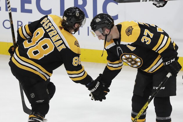 Boston Bruins right wing David Pastrnak (88) and center Patrice Bergeron (37) celebrate the team's 5-4 victory over the Winnipeg Jets in an NHL hockey game Thursday, Jan. 9, 2020, in Boston. Pastrnak scored three goals in the game. (AP Photo/Elise Amendola)