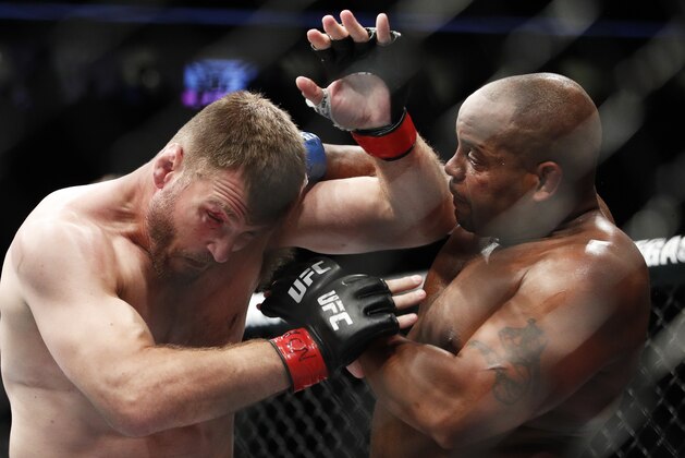 FILE - In this July 7, 2018, file photo, Daniel Cormier, right, fights Stipe Miocic during a heavyweight title mixed martial arts bout at UFC 226 in Las Vegas. The trilogy fight between Daniel Cormier and champ Stipe Miocic will crown the greatest heavyweight of all time. UFC 252 Saturday, Aug. 15, 2020, in Las Vegas could be Cormier's last fight ever. (AP Photo/John Locher, File)