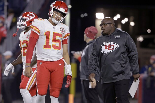 FILE - In this Oct. 14. 2018, file photo, Kansas City Chiefs quarterback Patrick Mahomes listens to offensive coordinator Eric Bieniemy, right, as he warms up for the team's NFL football game against the New England Patriots in Foxborough, Mass. The Miami Dolphins have begun their search for a coach who’s ready to lose this year. New England Patriots linebackers coach Brian Flores and Bieniemy, the first candidates to interview for the Dolphins’ job, met with them Friday, Jan. 4. Owner Stephen Ross is seeking a replacement for Adam Gase, and wants to rebuild after a 7-9 season. (AP Photo/Steven Senne)