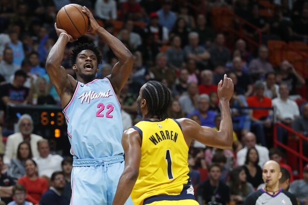 Miami Heat forward Jimmy Butler (22) shoot as Indiana Pacers forward T.J. Warren (1) watches during the second half of an NBA basketball game Friday, Dec. 27, 2019, in Miami. The Heat won 113-112. (AP Photo/Wilfredo Lee)