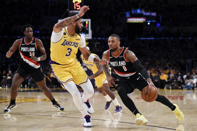Portland Trail Blazers guard Damian Lillard handles the ball while Los Angeles Lakers forward Anthony Davis defends during the first half of an NBA basketball game in Los Angeles, Friday, Jan. 31, 2020. (AP Photo/Kelvin Kuo)