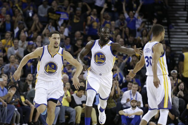 Golden State Warriors, from left, Klay Thompson, Draymond Green, and Stephen Curry celebrate a score against the Los Angeles Clippers during the first half of a preseason NBA basketball game Tuesday, Oct. 4, 2016, in Oakland, Calif. (AP Photo/Ben Margot)