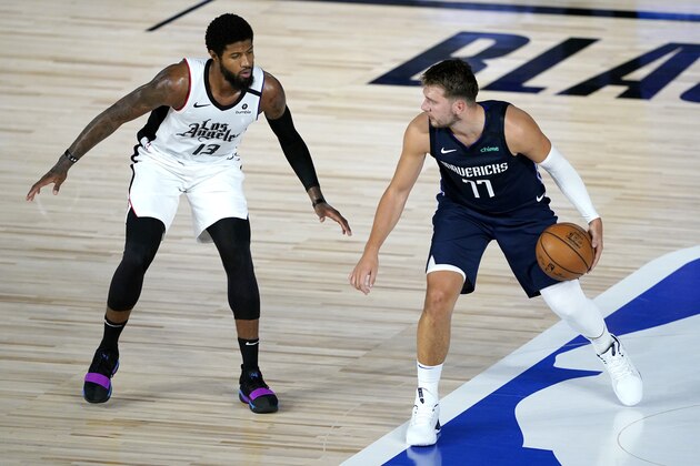 Dallas Mavericks' Luka Doncic (77) works the floor against Los Angeles Clippers' Paul George (13) during the first half of an NBA basketball game Thursday, Aug. 6, 2020 in Lake Buena Vista, Fla. (AP Photo/Ashley Landis, Pool)