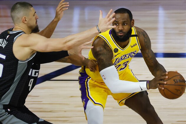 Los Angeles Lakers' LeBron James (23) is pressured by Sacramento Kings' Alex Len (25) during the first half of an NBA basketball game Thursday, Aug. 13, 2020, in Lake Buena Vista, Fla. (Kevin C. Cox/Pool Photo via AP)