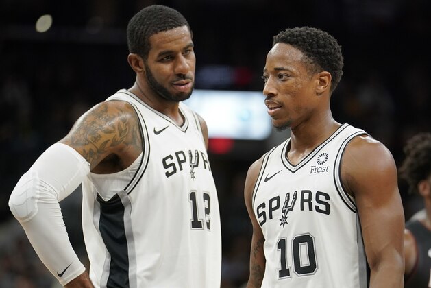 San Antonio Spurs' DeMar DeRozan (10) and LaMarcus Aldridge talk during the first half of an NBA preseason basketball game against the Miami Heat, Sunday, Sept. 30, 2018, in San Antonio. (AP Photo/Darren Abate)