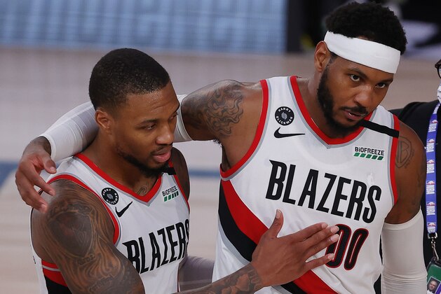 Portland Trail Blazers' Carmelo Anthony, right, and Damian Lillard celebrate the team's win over the Philadelphia 76ers in an NBA basketball game Sunday, Aug. 9, 2020, in Lake Buena Vista, Fla. (Kevin C. Cox/Pool Photo via AP)