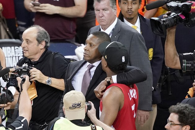 FILE - In this June 13, 2019, file photo, Toronto Raptors President Masai Ujiri, center left, walks with his arm around guard Kyle Lowry after the Raptors defeated the Golden State Warriors in basketball's NBA Finals in Oakland, Calif. On Tuesday, Oct. 22, 2019, the Alameda County District Attorney's Office announced no criminal charges will be filed against Ujiri for an incident involving Ujiri and an Alameda County sheriff's deputy after Game 6 of the finals. (AP Photo/Tony Avelar, File)