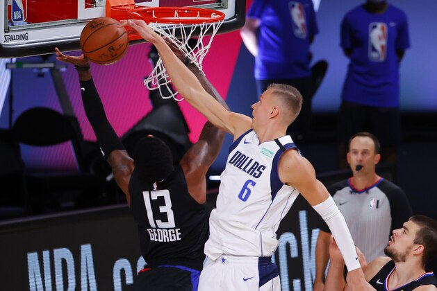 Dallas Mavericks' Kristaps Porzingis (6) fouls Los Angeles Clippers' Paul George (13) during the second quarter of Game 1 of an NBA basketball first-round playoff series, Monday, Aug. 17, 2020, in Lake Buena Vista, Fla. (Kevin C. Cox/Pool Photo via AP)
