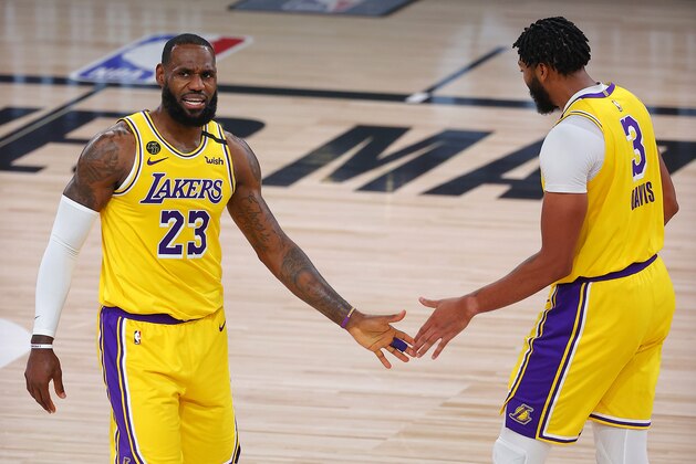 Los Angeles Lakers' LeBron James, left, and Anthony Davis react after a shot during the third quarter against the Portland Trail Blazers in Game 1 of an NBA basketball first-round playoff series, Tuesday, Aug. 18, 2020, in Lake Buena Vista, Fla. (Mike Ehrmann/Pool Photo via AP)