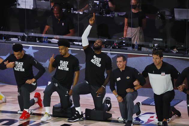 Los Angeles Lakers' LeBron James points up following the national anthem before the start of an NBA basketball game against the Sacramento Kings Thursday, Aug. 13, 2020, in Lake Buena Vista, Fla. (Kevin C. Cox/Pool Photo via AP)
