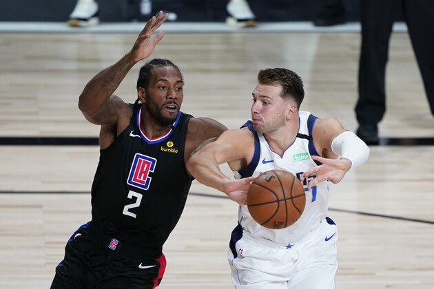 Dallas Mavericks' Luka Doncic, right, passes as he is defended by Los Angeles Clippers' Kawhi Leonard (2) during the first half of an NBA basketball game Wednesday, Aug. 19, 2020, in Lake Buena Vista, Fla. (AP Photo/Ashley Landis, Pool)