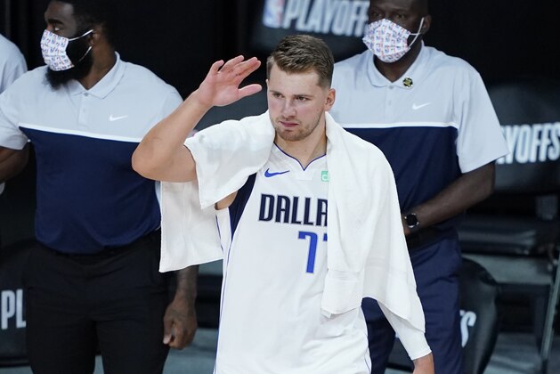 Dallas Mavericks' Luka Doncic (77) congratulates teammates at the end of an NBA basketball game against the Los Angeles Clippers Wednesday, Aug. 19, 2020, in Lake Buena Vista, Fla. Dallas won 127-114. (AP Photo/Ashley Landis, Pool)
