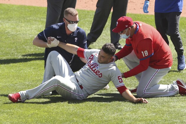 Philadelphia Phillies pitcher Jose Alvarez is helped after being hit by a ball hit by Toronto Blue Jays' Lourdes Gurriel Jr. during the fifth inning of the first game of a baseball doubleheader, Thursday, Aug. 20, 2020, in Buffalo, N.Y. (AP Photo/Jeffrey T. Barnes)