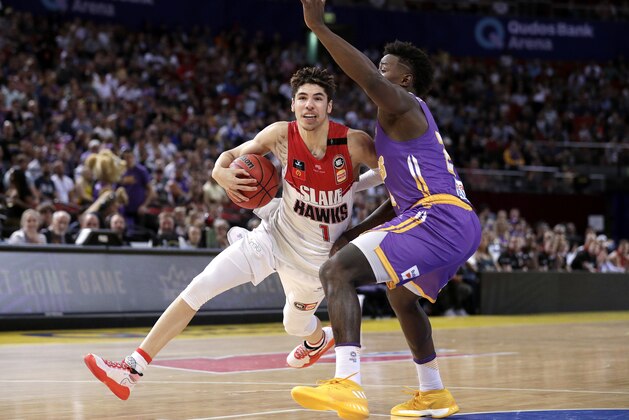 LaMelo Ball of the Illawarra Hawks drives past Jae'Sean Tate of the Sydney Kings during their game in the Australian Basketball League in Sydney, Sunday, Nov. 17, 2019. (AP Photo/Rick Rycroft)