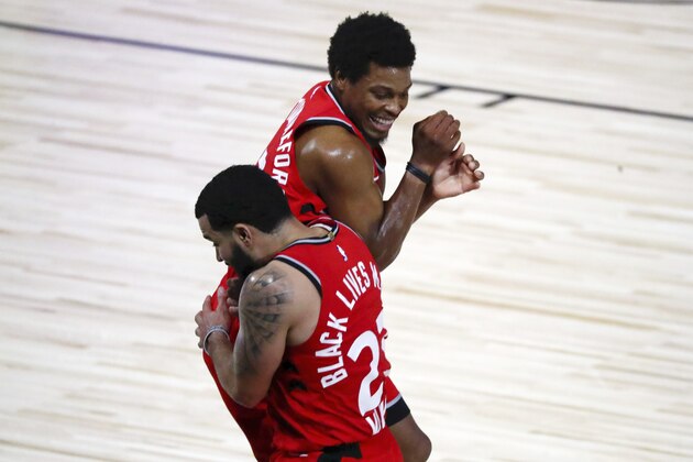 Toronto Raptors guard Fred VanVleet (23) celebrates with guard Kyle Lowry (7) after making a half court shot against the Brooklyn Nets to end the first half in Game 3 of an NBA basketball first-round playoff series, Friday, Aug. 21, 2020, in Lake Buena Vista, Fla. (Kim Klement/Pool Photo via AP)