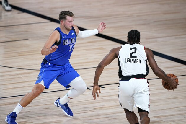 Los Angeles Clippers' Kawhi Leonard (2) drives against Dallas Mavericks' Luka Doncic (77) during the first half of an NBA basketball first round playoff game Friday, Aug. 21, 2020, in Lake Buena Vista, Fla. (AP Photo/Ashley Landis, Pool)