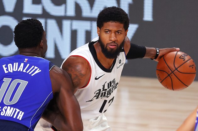 Los Angeles Clippers' Paul George, right, looks to pass against Dallas Mavericks' Dorian Finney-Smith (10) during the fourth quarter of Game 3 of an NBA basketball first-round playoff series, Friday, Aug. 21, 2020, in Lake Buena Vista, Fla. (Mike Ehrmann/Pool Photo via AP)