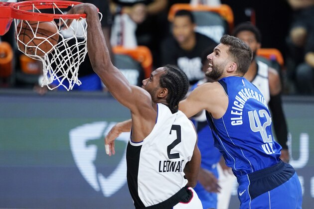 Los Angeles Clippers' Kawhi Leonard (2) scores ahead of Dallas Mavericks' Maxi Kleber (42) during the second half of an NBA basketball first round playoff game Friday, Aug. 21, 2020, in Lake Buena Vista, Fla. The Clippers won 130-122. (AP Photo/Ashley Landis, Pool)