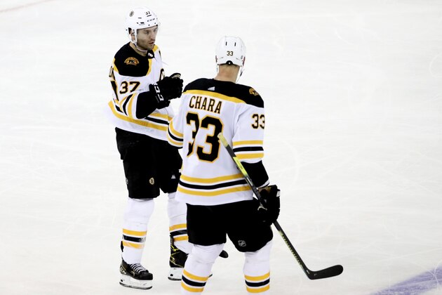 Boston Bruins center Patrice Bergeron (37) celebrates with Zdeno Chara after scoring a goal against the New York Rangers during the third period of an NHL hockey game, Sunday, Feb. 16, 2020, at Madison Square Garden in New York. (AP Photo/Mary Altaffer
