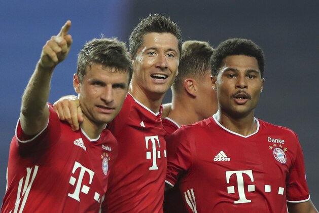 Bayern's Serge Gnabry, right, celebrates his side's second goal with teammates Robert Lewandowski, center, and Thomas Mueller during the Champions League semifinal soccer match between Lyon and Bayern Munich at the Jose Alvalade stadium in Lisbon, Portugal, Wednesday, Aug. 19, 2020. (Miguel A. Lopes/Pool via AP)