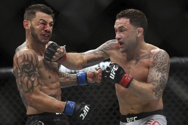 Frankie Edgar, right, hits Cub Swanson during the third round of their UFBC mixed martial arts featherweight bout early Sunday, April 22, 2018, in Atlantic City, N.J. Edgar won the bout. (AP Photo/Mel Evans)