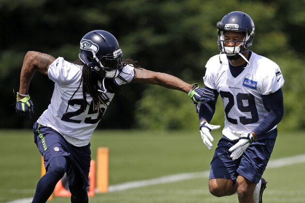 Seattle Seahawks' Richard Sherman (25) and Earl Thomas (29) run through a drill at an NFL football practice Wednesday, June 1, 2016, in Renton, Wash. (AP Photo/Elaine Thompson)
